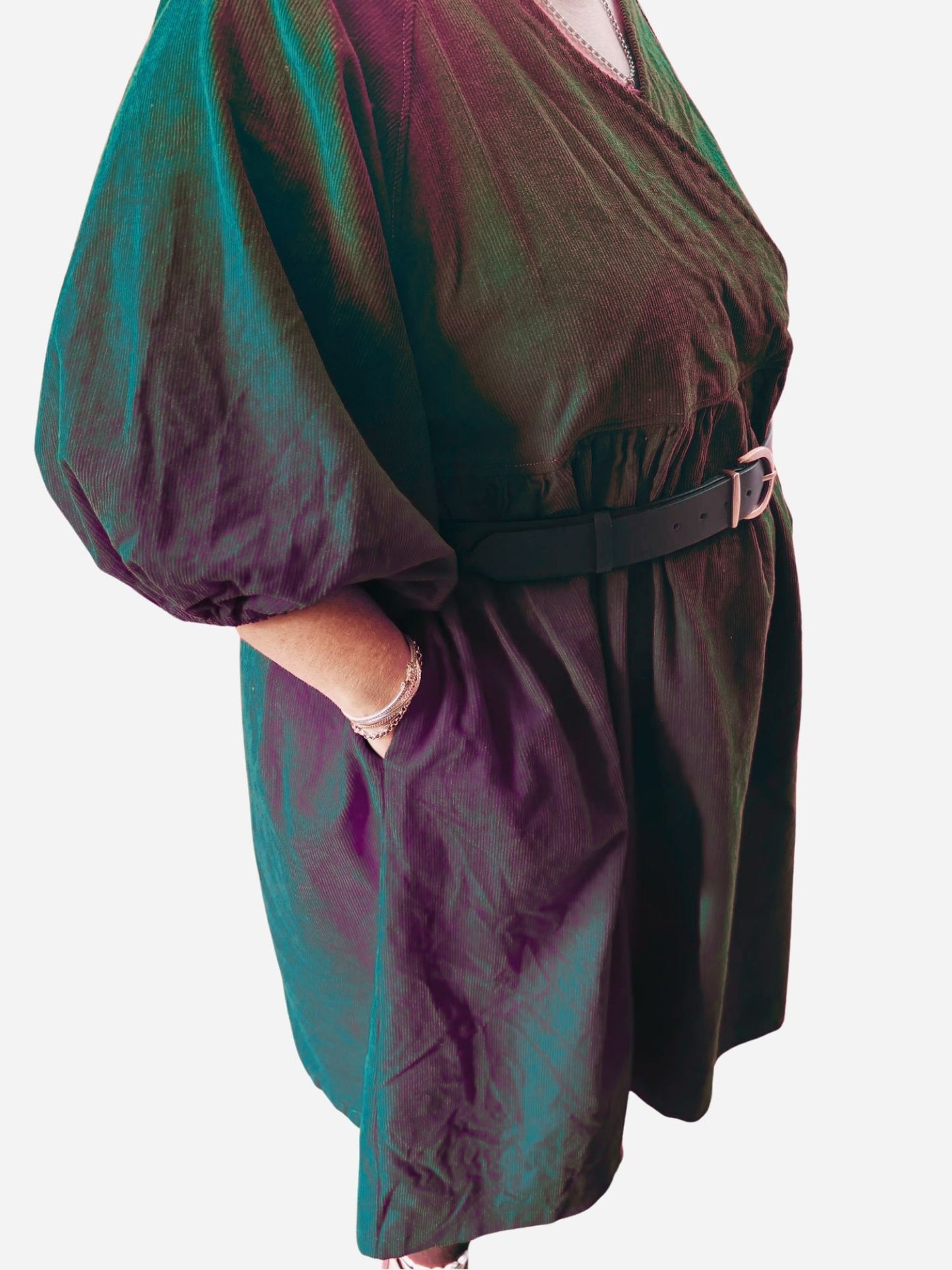 Person wearing a red dress with puffed sleeves on a wooden deck.