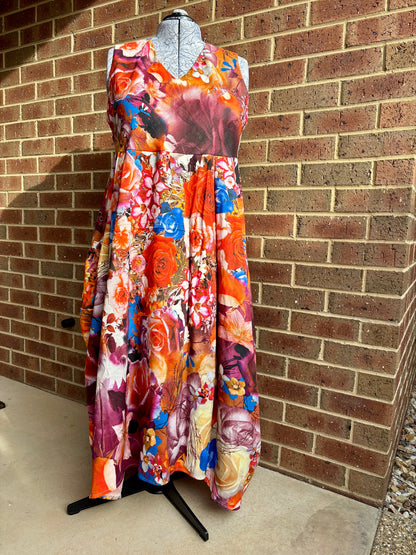 Colorful floral dress on a mannequin against a brick wall.