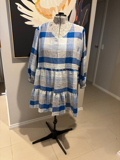 Blue and white checkered dress on a mannequin against a neutral background