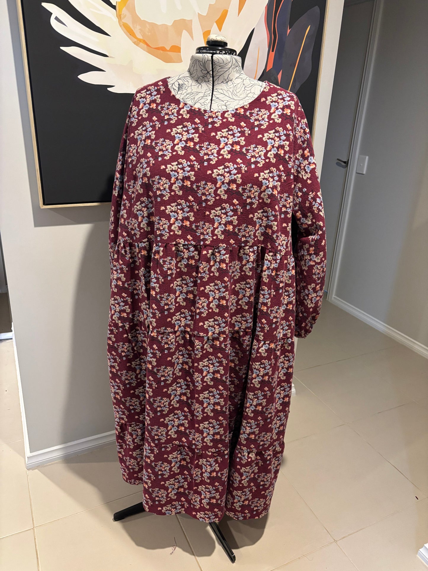 Maroon floral-patterned garment on a white surface with a neutral background