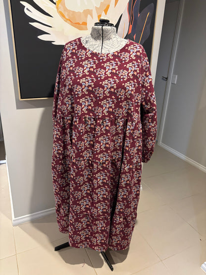 Maroon floral-patterned garment on a white surface with a neutral background